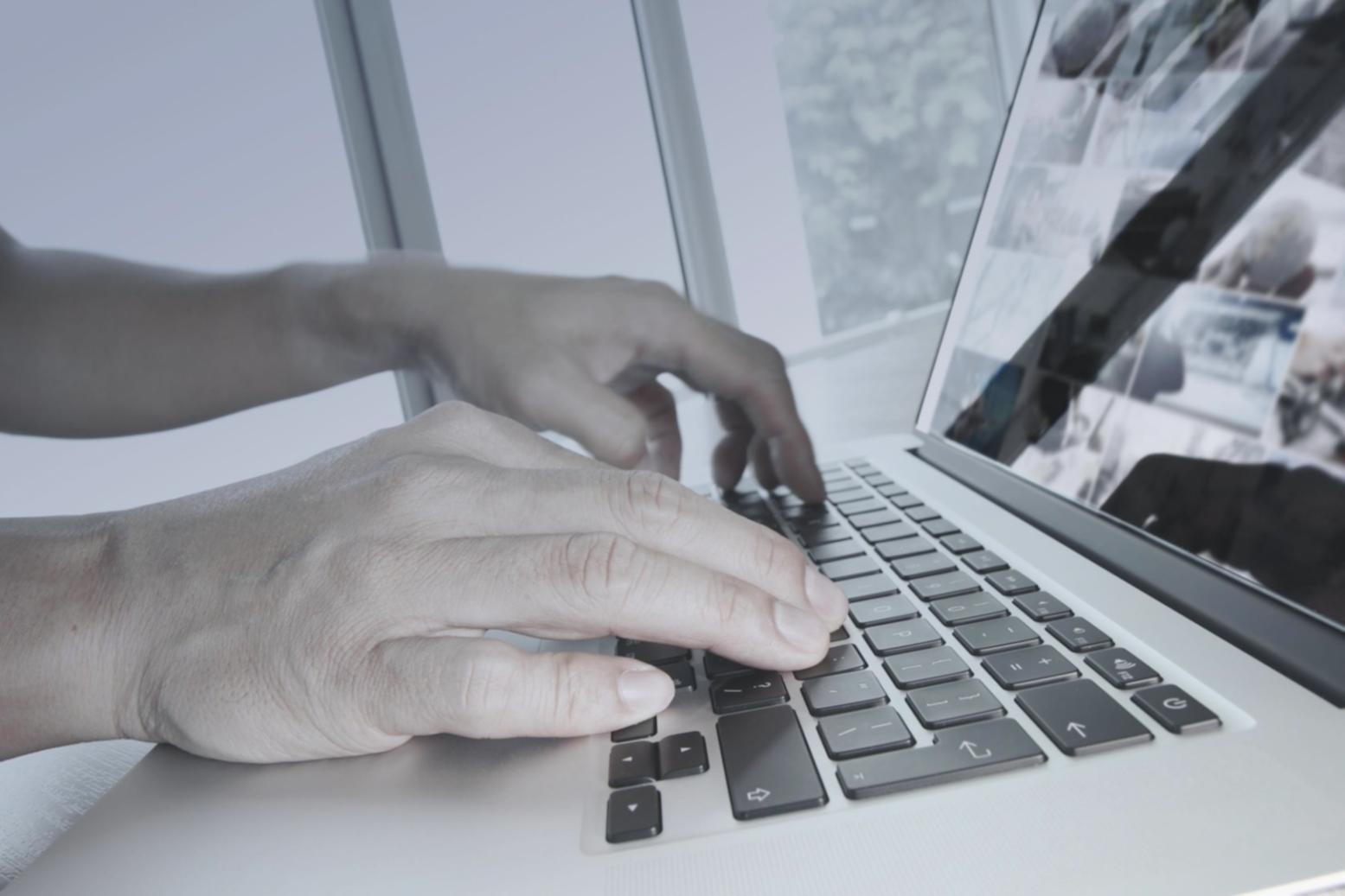 Modern office workspace showing game development team collaborating on project with multiple screens displaying 3D models and code